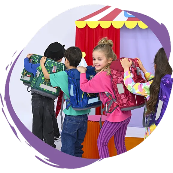 Vier Kinder bilden eine Schlange und haben die Hände beim Vordermann auf den Schultern